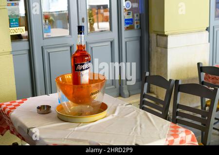Gesamtansicht einer Flasche Aperol Aperitif Spritz in einer Aperol Schale auf einem Tisch in einem Outdoor Cafe in Athen, Griechenland am 29 2021. November. Stockfoto