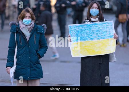 Frankfurt, Deutschland. 25.. Februar 2022. 25. Februar 2022, Hessen, Frankfurt/Main: Eine junge Frau hält bei einer Mahnwache in der Frankfurter Hauptwache eine selbstgemalte ukrainische Flagge als Ausdruck der Solidarität mit der Ukraine nach der russischen Invasion des Landes. Foto: Hannes P. Albert/dpa Quelle: dpa picture Alliance/Alamy Live News Stockfoto