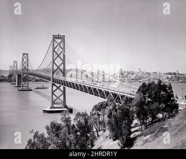 1940S 1950S WESTERN SPAN OF THE OAKLAND BAY BRIDGE MIT BLICK AUF SF VON YERBA BUENA ISLAND AUS GESEHEN SAN FRANCISCO CA USA - B4827 HAR001 HARS CONCEPTUAL 1936 CITIES OAKLAND BUENA OAKLAND BAY BRIDGE SAN FRANCISCO BUILT SPAN BLACK AND WHITE BRIDGES CABLE DESIGNED HAR001 OLD FASHIONED SUSPENSION Stockfoto