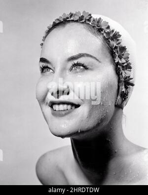 1960S LÄCHELNDE FRAU TRÄGT GEBLÜMTEN GUMMI BADEN CAP NASSES GESICHT SUCHEN NACH OBEN - G2424 CLE003 HARS FRISCH PRETTY HAPPINESS WELLNESS KOPF UND SCHULTERN FRÖHLICH ERHOLUNG GESUND BIS LÄCHELT SCHWIMMER GUTE GESUNDHEIT FRÖHLICH STILVOLLER TEINT GEBLÜHT FRISCH GESICHTIG JUNGE ERWACHSENE FRAU SCHWARZ UND WEISS KAUKASISCHEN ETHNIE ALTMODISCH Stockfoto