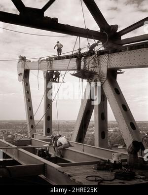 1950S SECHS MÄNNER, DIE AUF BALKEN GEHEN UND EINE BRÜCKE ZWISCHEN DEN DREHTECHTEN VON PENNSYLVANIA UND NEW JERSEY BAUEN - I650 HAR001 HARS MÄNNER RISIKO SECHS BERUF VERTRAUEN TRANSPORT B & W KNIEND GESCHICKLICHKEIT BERUF FÄHIGKEITEN HIGH ANGLE GEFÄHRLICHE STÄRKE MUT UND KARRIERE WAHL SPANNUNG WISSEN PA KRAFTVOLLER FORTSCHRITT ARBEIT STOLZ AUF GELEGENHEIT BESCHÄFTIGUNG NJ BERUFE VERBINDUNG KONZEPTIONELLE HARTHÜTE BALKEN VERBINDEN INFRASTRUKTUR NEW JERSEY MITARBEITER TURNPIKE DELAWARE RIVER PRECISION SCHWARZ-WEISS HAR001 LABORING ALTMODISCH Stockfoto