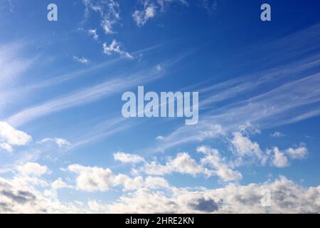 Blauer Himmel bedeckt mit weißen Cumulus- und Zirruswolken. Frühlingswolkenlandschaft, schöner Wetterhintergrund Stockfoto