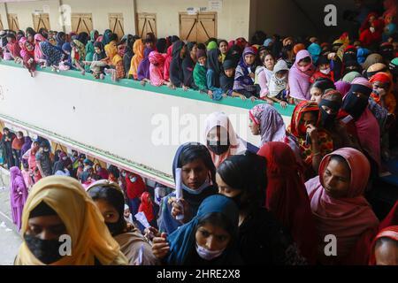 Am 25. Februar 2022 warten Menschen in einer Schlange, um den Covid-19-Impfstoff in einem Impfzentrum in Narayanganj, Bangladesch, zu erhalten. Einige Impfzentren waren überwältigt, als Tausende am Freitag, einen Tag vor der Impfung von 10 Millionen Menschen in einer eintägigen landesweiten Fahrt, versuchten, ihre erste Dosis des Coronavirus-Impfstoffs zu erhalten. Menschen, die um 6am Uhr im Delpara High School Center in Narayanganj Sadar Upazilas Kutubpur ankamen, stellten sich für nealy sechs Stunden in die Schlange, um ihre COVID-Impfdosen zu erhalten. Die Regierung wird die Verabreichung der ersten Dosen des Coronavirus-Impfstoffs an Bürger nach 1 einstellen Stockfoto