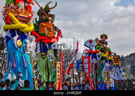 Parade mit 5 Meter hohen, 30 kg schweren verzierten Holzstangen, die den Göttern bei der Bonden-Zeremonie während des Yokote Kamakura Festivals, Yokote, Akita Pre angeboten werden Stockfoto