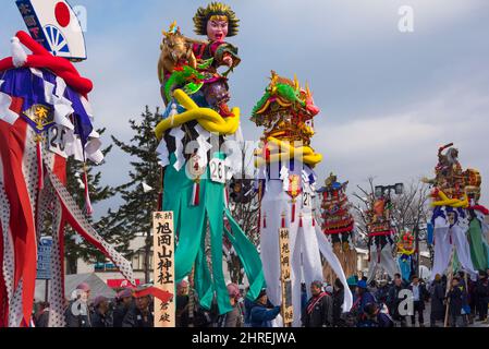 Parade mit 5 Meter hohen, 30 kg schweren verzierten Holzstangen, die den Göttern bei der Bonden-Zeremonie während des Yokote Kamakura Festivals, Yokote, Akita Pre angeboten werden Stockfoto