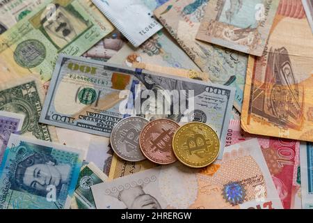 Kryptowährungsmünzen auf einer weltweiten Papierwährung Stockfoto