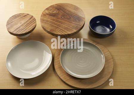 Sammlung von Tellern, Schüsseln und hölzernen Utensilien auf einem Holztisch Stockfoto