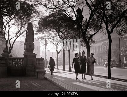 1930S 1940S SONNENUNTERGANG SCHAFFT STIMMUNGSVOLLE ATMOSPHÄRE FÜR DREI FRAUEN, DIE ZUSAMMEN ENTLANG DES PLAZA CONGRESS BUENOS AIRES ARGENTINIEN - R12624 PAL001 HARS ENTLANG DER ERHOLUNG BUMMELN KONZEPTIONELL STILVOLLES ARGENTINIEN PLAZA AIRES ANONYM BUENOS AM SPÄTEN NACHMITTAG VON BÄUMEN GESÄUMT BUENOS AIRES KONGRESS SCHAFFT MID-ADULT FRAU ENTSPANNUNG ZWEISAMKEIT ATMOSPHÄRE SCHWARZ-WEISS ALTMODISCH Stockfoto