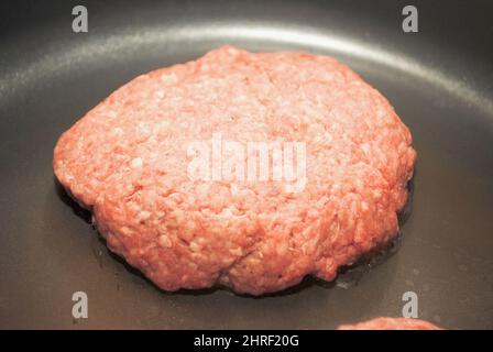 Burger in einer schwarzen Pfanne braten Stockfoto