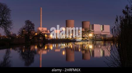 Farbige Nachtaufnahme eines Kohlekraftwerks. Im Vordergrund der Kanal für die Lieferung der Kohle Stockfoto