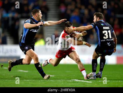 St Helens' Lewis Dodd (Mitte) versucht, an Thomas Minns von Wakefield Trinity (rechts) vorbei zu kommen, wird aber während des Betfred Super League-Spiels im Totally Wicked Stadium, St. Helens, ins Gesicht gepackt. Bilddatum: Freitag, 25. Februar 2022. Stockfoto