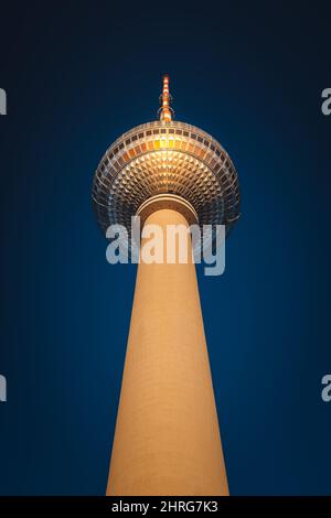 Vertikale Aufnahme des Berliner Fernsehturms in Berlin, Deutschland auf blauem Himmel Stockfoto