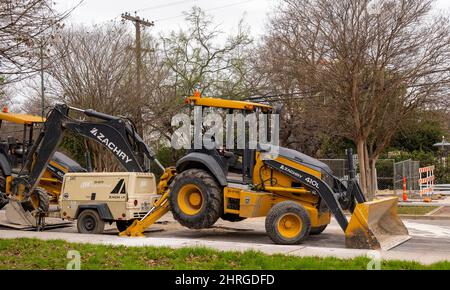 SAN ANTONIO, TX - 25. JAN 2020: Seitenansicht der Frontlader, schwere Ausrüstung mit Hinterhacke auf einer Straßenbaustelle auf der Stadtstraße. Stockfoto