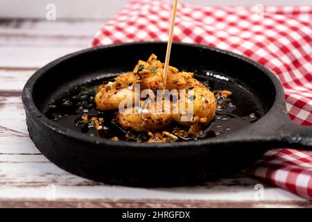 Traditionelles spanisches Gericht, typische mediterrane Tapas. Garnelen mit Knoblauch oder Garnelen mit Knoblauch in Olivenöl. Traditionelles Food-Konzept. Normale Ansicht. Stockfoto