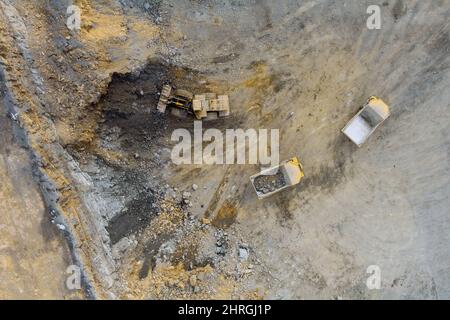 Schwere Muldenkipper mit Kalksteinerz bewegt sich in einem Steinbruch entlang der Straße Stockfoto