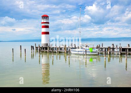 Leuchtturm mit Holzsteg in Podersdorf am See, einem kleinen Dorf am Neusiedler See mit dem längsten Strand im Burgenland, Österreich. Stockfoto