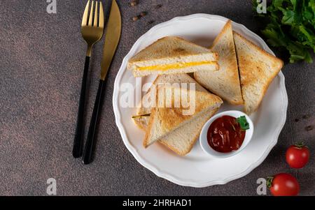 Sandwiches mit Ei und Käse, gebraten in der Pfanne, serviert mit Tomatensauce zum Frühstück, Blick von oben Stockfoto