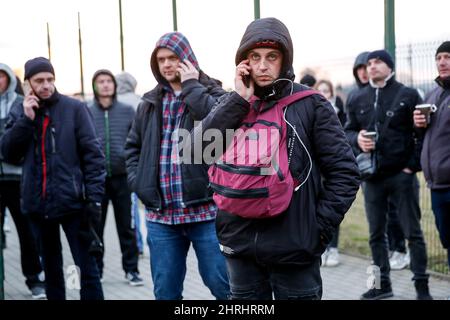 Ukrainische Männer warten am Grenzübergang auf die Ankunft ihrer Angehörigen, als Zehntausende Flüchtlinge aus der Ukraine nach Polen einreisen, nachdem Russland am 25. Februar 2022 mehr ukrainisches Territorium einbemächtigt hat – den polnisch-ukrainischen Grenzübergang in Medyka, Polen. Da die Armee der Russischen Föderation die ukrainischen Grenzen überschritten hat, wird der Konflikt zwischen der Ukraine und Russland voraussichtlich 5 Millionen Ukrainer zur Flucht zwingen. Die meisten Flüchtlinge werden in Polen Asyl beantragen. Die meisten der derzeitigen Flüchtlinge sind Familien jener Ukrainer, die bereits in Polen arbeiten. An den Grenzübergängen warten Tausende von Männern und Frauen Stockfoto