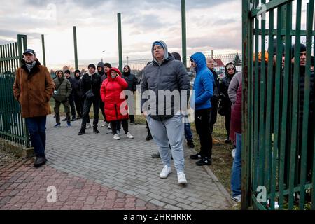 Die Ukrainer warten an der Grenzpassage auf die Ankunft ihrer Angehörigen, während Zehntausende Flüchtlinge aus der Ukraine nach Polen einreisen, nachdem Russland am 25. Februar 2022 mehr ukrainisches Territorium einbemächtigt hat – den polnisch-ukrainischen Grenzübergang in Medyka, Polen. Da die Armee der Russischen Föderation die ukrainischen Grenzen überschritten hat, wird der Konflikt zwischen der Ukraine und Russland voraussichtlich 5 Millionen Ukrainer zur Flucht zwingen. Die meisten Flüchtlinge werden in Polen Asyl beantragen. Die meisten der derzeitigen Flüchtlinge sind Familien jener Ukrainer, die bereits in Polen arbeiten. An den Grenzübergängen warten Tausende von Männern und Frauen darauf Stockfoto