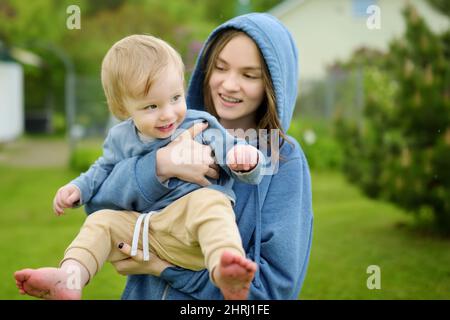 Nette große Schwester kuscheln mit ihrem kleinen Bruder. Liebenswert ...