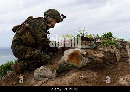 Iirusna, Okinawa, Japan. 16.. Februar 2022. Die US Marine Corps Maj. Jessica Lucia, Luftoffizierin, 12. Marineinfanteristen, sammelt Targeting-Daten für eine indirekte Feuermission während der Dschungelkriegsübung 22 vor der Küste von Okinawa, Japan, 16. Februar 2022. JWX 22 ist eine groß angelegte Schulung vor Ort, die sich auf die Nutzung der integrierten Fähigkeiten gemeinsamer und verwandter Partner konzentriert, um das Bewusstsein, die Manöver und die Brände in einer verteilten maritimen Umgebung zu stärken. 2/7 wird im Indo-Pazifik-Raum unter 4. Marines, 3D Marine Division, als Teil des Unit Deployment Program eingesetzt. (Cre Stockfoto