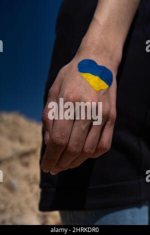 Weibliche Hand in Ukraine Flagge Farben mit Herzform gemalt Stockfoto