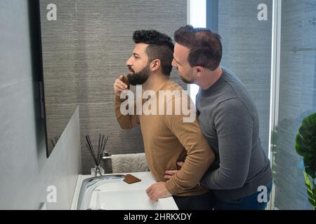 Nahaufnahme eines Homosexuell verheiratet Umarmung im Badezimmer ihres Hauses Stockfoto