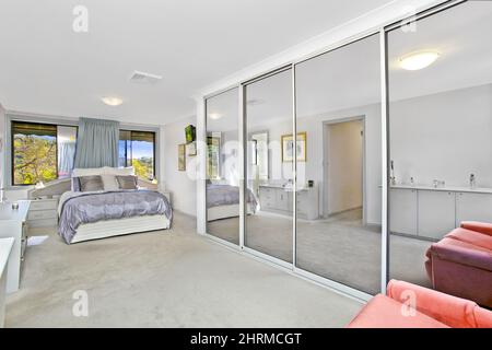 Schlafzimmer innen mit Kleiderschrank mit Glastüren Stockfoto