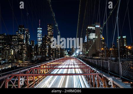 Luftaufnahme einer berühmten Brooklyn-Brücke und Stadtbild auf der Rückseite, aufgenommen während der Nacht Stockfoto