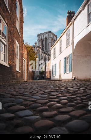 Blick auf das York Minster von der Chapter House Street, tief angeschossen mit den Kopfsteinpflaster. Stockfoto