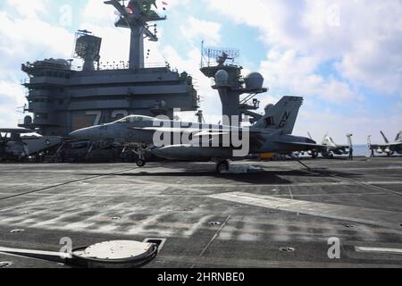 PHILIPPINISCHES MEER (Feb 24, 2022) Konteradmiral J.T. Anderson, Kommandant der Carrier Strike Group 3, landet auf dem Flugdeck des Nimitz-Klasse-Flugzeugträgers USS Abraham Lincoln (CVN 72) in einer F/A-18E Super Hornet, die den 'Tophattern' des Strike Fighter Squadron (VFA) 14 zugewiesen wurde. Die Abraham Lincoln Strike Group befindet sich im geplanten Einsatzgebiet der US-Flotte für 7., um die Interoperabilität durch Allianzen und Partnerschaften zu verbessern und gleichzeitig als reaktionsfähige Truppe zur Unterstützung einer freien und offenen Region im Indo-Pazifik-Raum zu dienen. (USA Navy Foto nach Mass Communication Spec Stockfoto