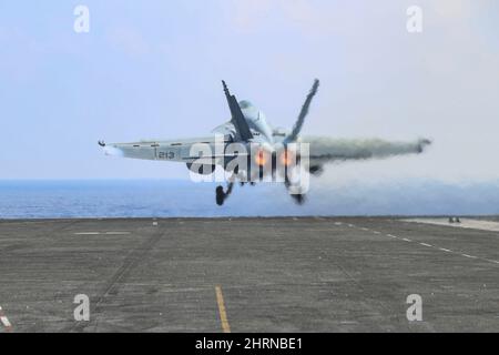 PHILIPPINISCHES MEER (Feb 24, 2022) Konteradmiral J.T. Anderson, Commander, Carrier Strike Group 3, startet in einer F/A-18E Super Hornet, die den 'Tophattern' von Strike Fighter Squadron (VFA) 14 zugewiesen wurde, vom Flugdeck des Nimitz-Klasse-Flugzeugträgers USS Abraham Lincoln (CVN 72) aus. Die Abraham Lincoln Strike Group befindet sich im geplanten Einsatzgebiet der US-Flotte für 7., um die Interoperabilität durch Allianzen und Partnerschaften zu verbessern und gleichzeitig als reaktionsfähige Truppe zur Unterstützung einer freien und offenen Region im Indo-Pazifik-Raum zu dienen. (USA Navy Foto von Mass Communication Specialist 3. Clas Stockfoto