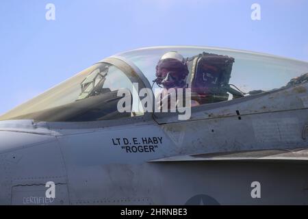PHILIPPINISCHES MEER (Feb 24, 2022) Konteradmiral J.T. Anderson, Commander, Carrier Strike Group 3, bereitet sich auf den Start in einer F/A-18E Super Hornet vor, die den „Tophattern“ des Strike Fighter Squadron (VFA) 14 vom Flugdeck des Nimitz-Klasse-Flugzeugträgers USS Abraham Lincoln (CVN 72) zugewiesen wurde. Die Abraham Lincoln Strike Group befindet sich im geplanten Einsatzgebiet der US-Flotte für 7., um die Interoperabilität durch Allianzen und Partnerschaften zu verbessern und gleichzeitig als reaktionsfähige Truppe zur Unterstützung einer freien und offenen Region im Indo-Pazifik-Raum zu dienen. (USA Navy Foto von Mass Communication Specialis Stockfoto