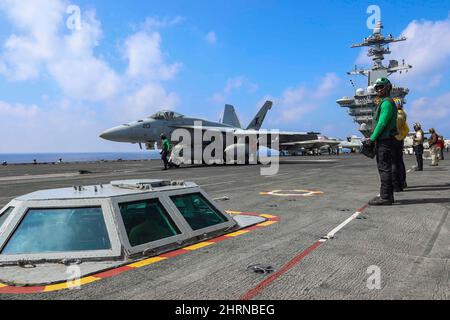 PHILIPPINISCHES MEER (Feb 24, 2022) Konteradmiral J.T. Anderson, Commander, Carrier Strike Group 3, bereitet sich auf den Start in einer F/A-18E Super Hornet vor, die den „Tophattern“ des Strike Fighter Squadron (VFA) 14 vom Flugdeck des Nimitz-Klasse-Flugzeugträgers USS Abraham Lincoln (CVN 72) zugewiesen wurde. Die Abraham Lincoln Strike Group befindet sich im geplanten Einsatzgebiet der US-Flotte für 7., um die Interoperabilität durch Allianzen und Partnerschaften zu verbessern und gleichzeitig als reaktionsfähige Truppe zur Unterstützung einer freien und offenen Region im Indo-Pazifik-Raum zu dienen. (USA Navy Foto von Mass Communication Specialis Stockfoto