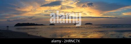 Panorama des spektakulären Sonnenuntergangs am einsamen Strand mit hellen Farben und keine Menschen mit Palmen auf Koh Chang Island, Thailand. Stockfoto