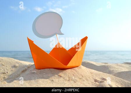 Orange Papier Boot auf Sandy Seashore Nahaufnahme kleines Boot aus Papier auf dem Hintergrund Stockfoto