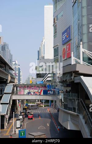 Blick auf die Skybridge oder den Fußgängerüberweg, der die BTS-Station Asok mit dem Einkaufszentrum Terminal 21 auf der rechten Seite, Bangkok, verbindet Stockfoto