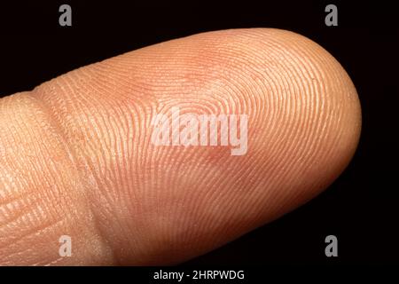 Nahaufnahme einer menschlichen Fingerhaut auf schwarzem Hintergrund Stockfoto