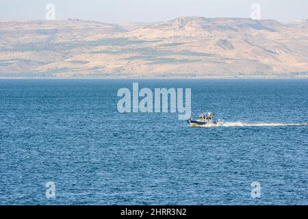 Ein Boot fährt über das blaue Wasser des Sees von Galilee in Israel. Stockfoto