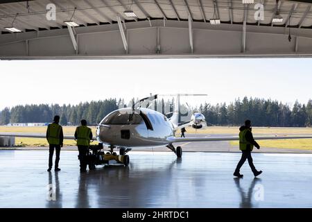 Arlington, Washington, USA. 25.. Februar 2022. Mitglieder der Bodenbesatzung Rollen das vollständig elektrische Alice-Prototypen-Flugzeug aus dem Hangar für einen Taxistest im Eviation-Hauptquartier im städtischen Flughafen Arlington. Eviation erwartet, dass Alice in den kommenden Wochen den ersten Flug antreten wird, bis weitere Vorbereitungen für Taxis und Flugtests anstehen. Quelle: Paul Christian Gordon/Alamy Live News Stockfoto