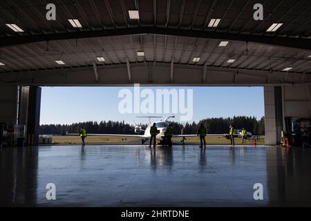 Arlington, Washington, USA. 25.. Februar 2022. Mitglieder der Bodenbesatzung Rollen das vollständig elektrische Alice-Prototypen-Flugzeug aus dem Hangar für einen Taxistest im Eviation-Hauptquartier im städtischen Flughafen Arlington. Eviation erwartet, dass Alice in den kommenden Wochen den ersten Flug antreten wird, bis weitere Vorbereitungen für Taxis und Flugtests anstehen. Quelle: Paul Christian Gordon/Alamy Live News Stockfoto