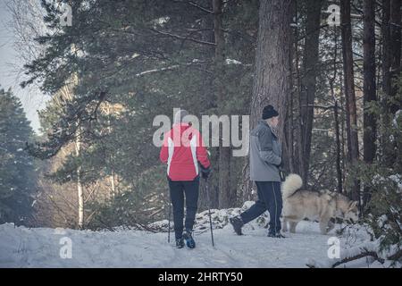 Ältere Paare, die im Winter in einem Wald in der Nähe von Vilnius, Litauen, spazieren gehen Stockfoto