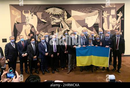 Vereinten Nationen. 25.. Februar 2022. Die UN-Botschafter der EU-Staaten versammelten sich zusammen mit ihrem Amtskollegen aus Kiew hinter einer ukrainischen Flagge. Das symbolische Foto wurde am Freitag vor einem „Guernica“-Wandteppich vor einem weiteren Notfalltreffen des mächtigsten UN-Organs über die russische Invasion in der Ukraine aufgenommen. Das Gemälde „Guernica“ des Künstlers Pablo Picasso gilt als eines der berühmtesten Denkmäler gegen den Krieg. Quelle: dpa picture Alliance/Alamy Live News Stockfoto