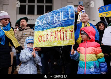 Ljubljana, Slowenien. 25.. Februar 2022. Kinder halten ein Plakat mit der Aufschrift „tötet nicht unsere Familie“ während einer Demonstration gegen Russlands militärische Invasion in der Ukraine. Nach dem russischen Einmarsch in die Ukraine versammelten sich Hunderte von Menschen in der slowenischen Hauptstadt, um gegen die russische Aggression zu protestieren. (Foto: Luka Dakskobler/SOPA Images/Sipa USA) Quelle: SIPA USA/Alamy Live News Stockfoto