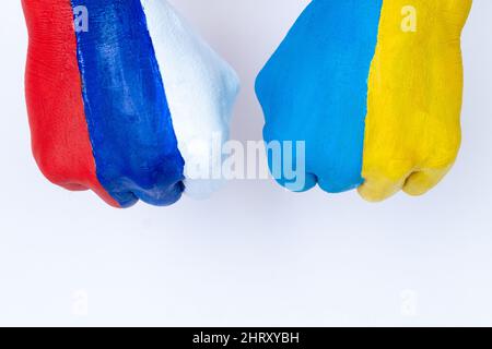 Flaggen der Ukraine und Russlands Flagge auf Händen auf weißem Hintergrund, Ukraine vs Russland im Weltkrieg Krisenkonzept. Stockfoto