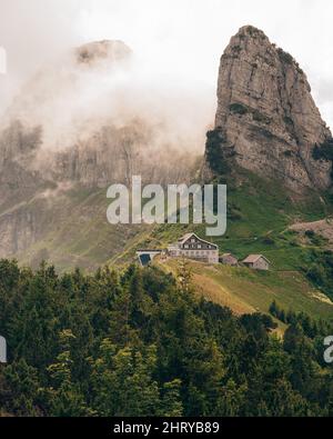 Schöne Aufnahme eines einsamen Hauses umgeben von Berglandschaft Stockfoto