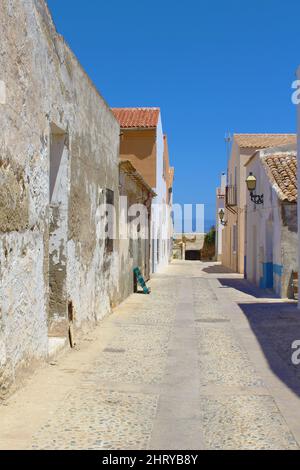 Vertikale Aufnahme einer engen Gasse aus alten Häusern unter blauem Himmel in Tabarca, Alicante, Spanien Stockfoto