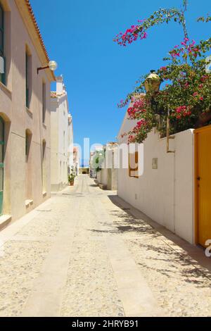 Vertikale Aufnahme einer engen Gasse aus alten Häusern unter blauem Himmel in Tabarca, Alicante, Spanien Stockfoto