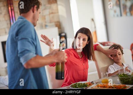 Möchten Sie, dass Ihre Kinder Sie so sehen? Aufnahme eines betrunkenen Mannes und seiner Frau, die während des Mittagessens vor ihren Kindern stritten. Stockfoto