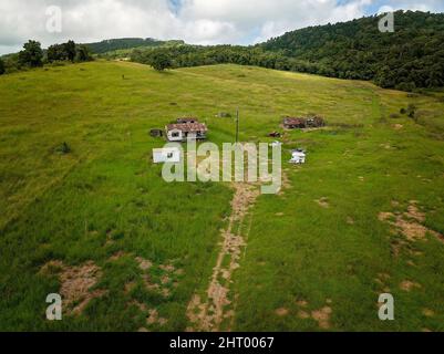 Ein verlassener Milchviehbetrieb mit den Besitzern, die das Land verlassen und die baufälligen Gebäude hinterlassen haben. Stockfoto